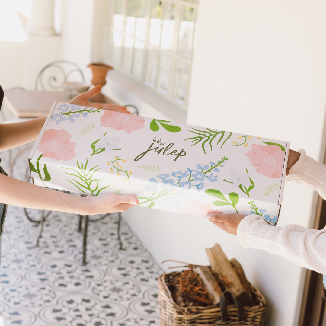 two ladies pass a julep box between them
